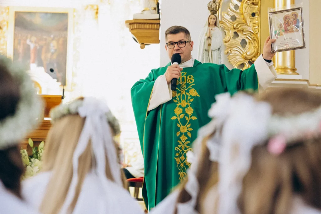 Ksiądz wygłasza homilię podczas Pierwszej Komunii Świętej