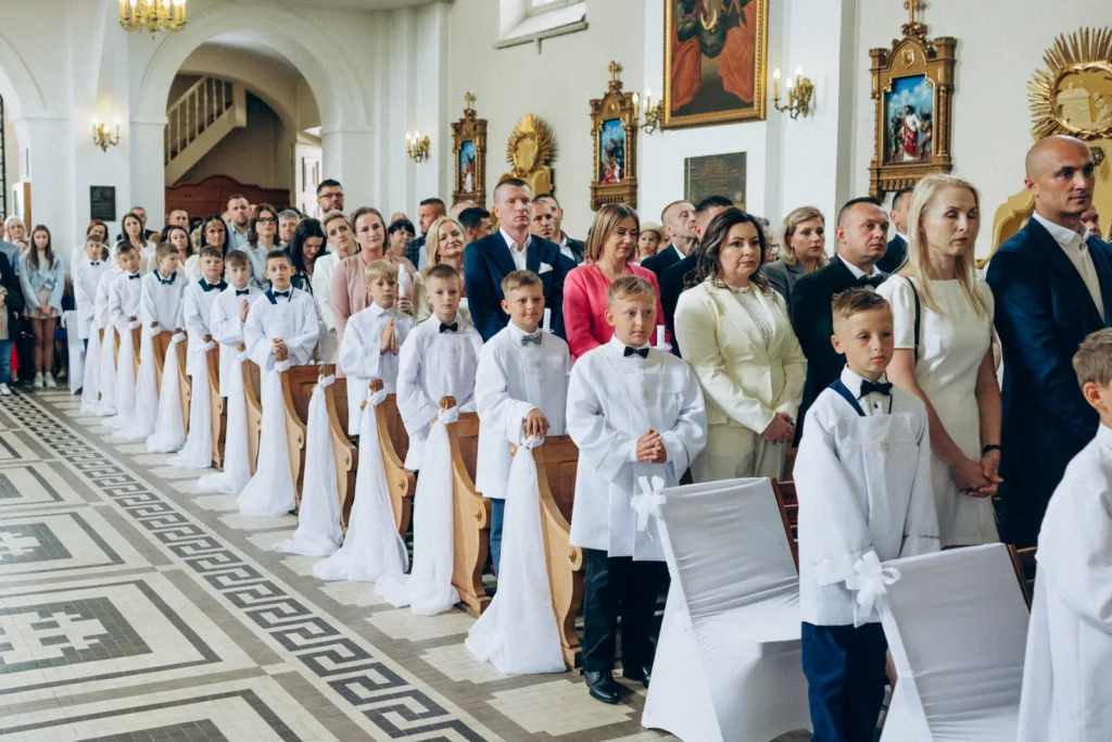 Dzieci pierwszokomunijne i rodziny podczas uroczystości w kościele